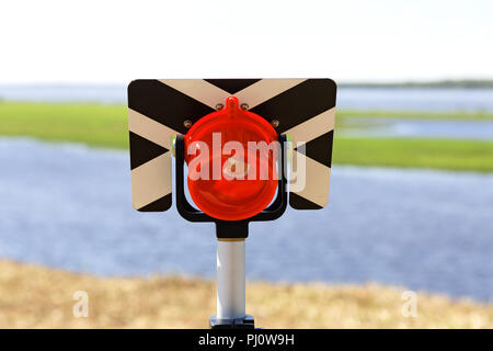 Modern reflector (milestone geodetic) for measuring distances by electronic total stations. Practical use outdoors Stock Photo