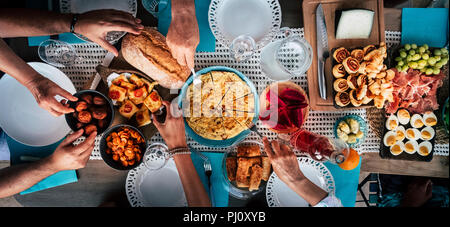 Food Catering Cuisine Culinary Gourmet Buffet Party Concept with lot of hands taking food from various mixed place on the table. having fu. community  Stock Photo