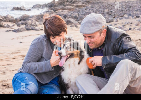 https://l450v.alamy.com/450v/pj0y2h/nice-group-of-dog-man-and-woman-young-people-having-fun-together-at-the-beach-drinking-tea-and-enjoying-the-outdoor-leisure-activity-fashion-people-pj0y2h.jpg