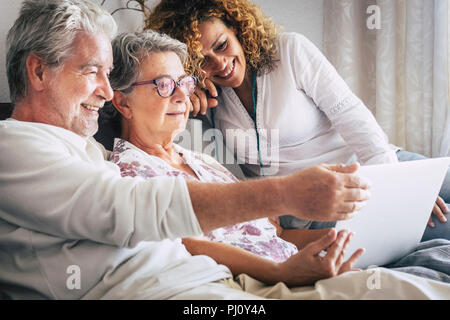 modern family at home sitting and using technology. mother and father and son with laptop computer and internet video conference. daily use of the web Stock Photo