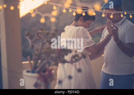 romantic couple dance together with love and romance during the down in the evening at home in the terrace. outdoor leisure activity for middle age wo Stock Photo