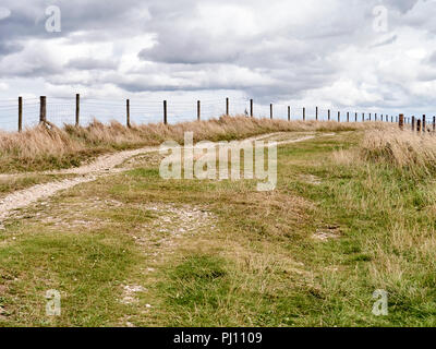 Fence-line on top of downland in Berkshire with clouds Stock Photo