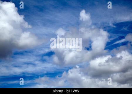 Cumulus and cirrus clouds over daytime sky in England Stock Photo