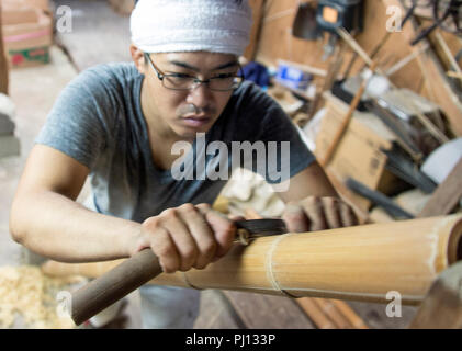 Shunichi Misawa strips lengths of bamboo in a process known as  Òkawa-migakiÓ (literally Òskin polishingÓ) at Iwao Chikuran's workshop in Beppu City,  Stock Photo