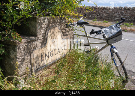 Close up of the sign marking the start of England from Scotland near Paxton England with a tandem bicycle resting against it. Stock Photo