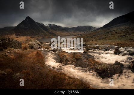 Afon Lloer in full spate as it rushes headlong down into Llyn Ogwen in Snowdonia, North Wales on a brooding and stormy day Stock Photo