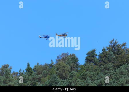2 old aircraft perform a low flypast of the Derwent Reservoir  in the Upper Derwent Valley of the Peak District National Park. Stock Photo