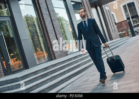 I did it! Full length of young man in full suit gesturing and shouting while walking outdoors Stock Photo