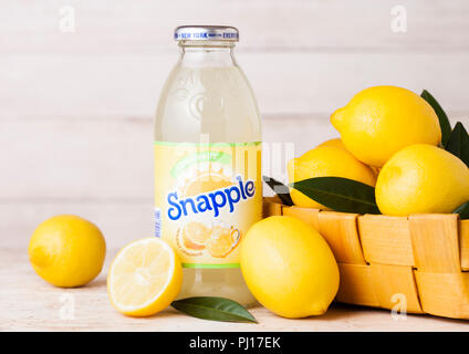 LONDON, UK - SEPTEMBER 03, 2018: Bottle of Snapple lemon juice on wooden background with fresh lemons in bamboo basket.Snapple is a product of the Dr  Stock Photo