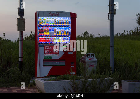 Japan Vending Machine in a remote and grassy area with can and bottle bin Stock Photo