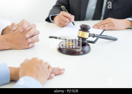 Angry couple arguing telling their problems to Judge gavel deciding on marriage to conclude an agreement on the divorce. They quarrel and argue with e Stock Photo