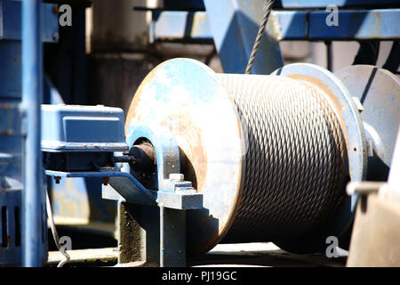 The close-up of the winch of a crane with a coiled steel rope. Stock Photo