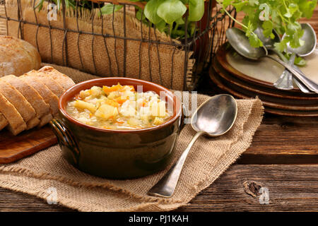 Vegetable soup in bowl with bread on wooden board with empty space for text Stock Photo