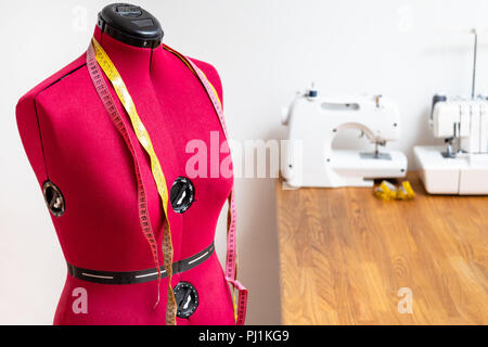 tailor's dummy with two measuring tapes in dressmaker workshop Stock Photo