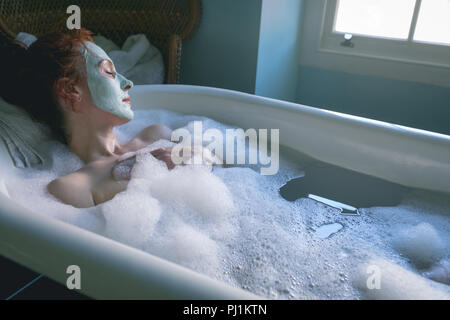 Woman relaxing in bathtub at bathroom Stock Photo