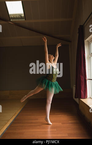 Ballerina practice arabesque ballet position in dance studio Stock Photo