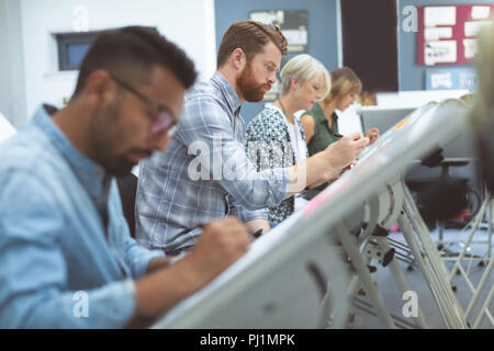 Executives working on drafting table Stock Photo