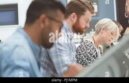 Executives working on drafting table in office Stock Photo