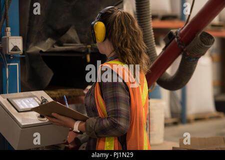 Female worker operating machine Stock Photo