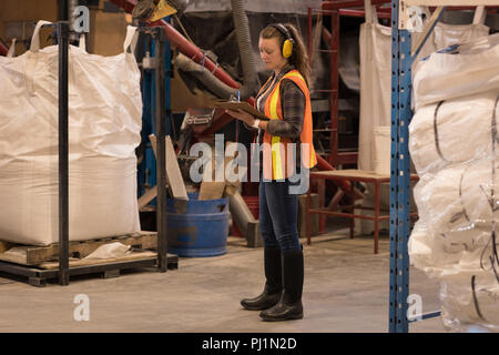 Female worker writing on clipboard Stock Photo