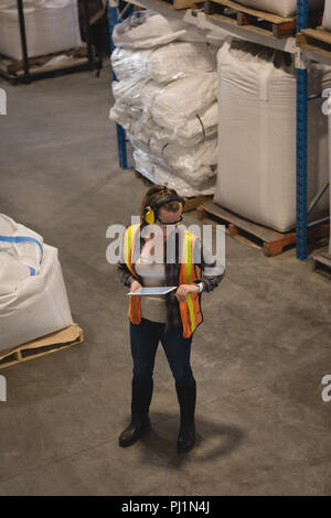 Female worker checking time while using digital tablet Stock Photo