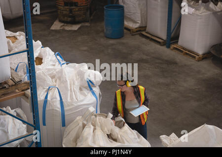 Female worker with digital tablet checking grains Stock Photo