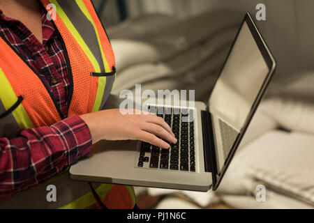 Female worker using laptop at  warehouse Stock Photo