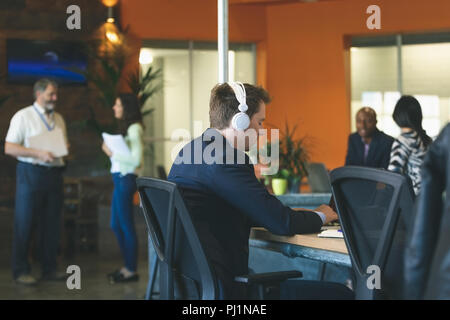 Businessman using laptop at desk Stock Photo