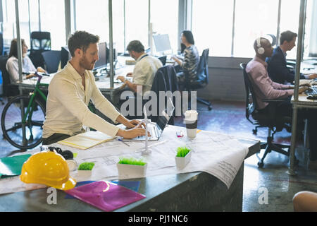 Male executive using laptop at desk Stock Photo