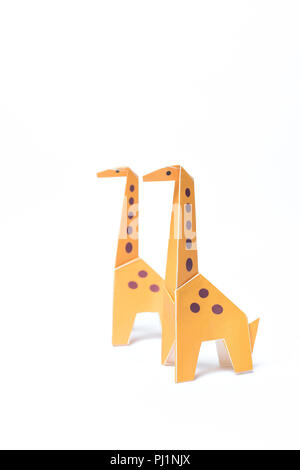 Two origami giraffes stand on a white background Stock Photo