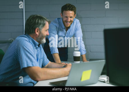 Business colleagues discussing over laptop Stock Photo