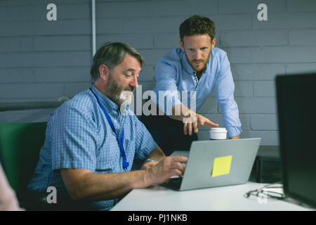 Business colleagues discussing over laptop Stock Photo