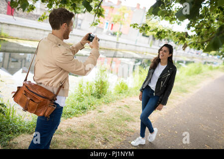 Man clicking picture of woman from digital camera Stock Photo