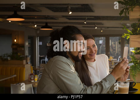 Couple taking selfie in cafe Stock Photo