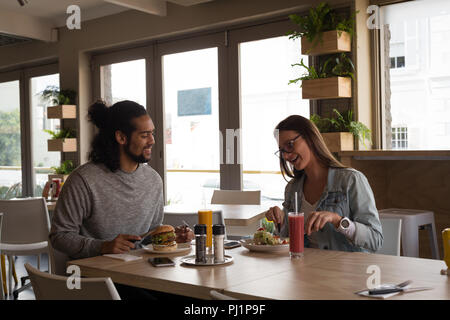 Couple having food in cafe Stock Photo