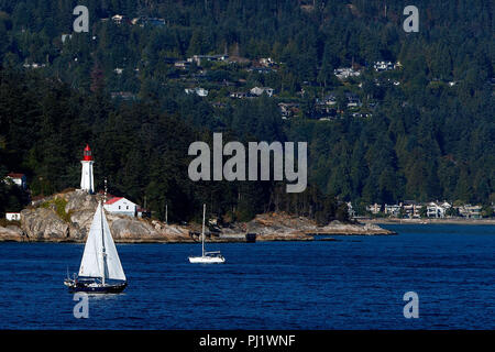 Point Atkinson Lighthouse with sailboat passing, West Vancouver, British Columbia, Canada Stock Photo