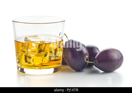 Plum brandy and plums. Tasty slivovitz isolated on white background. Stock Photo
