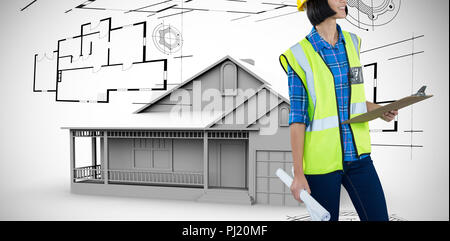 Composite image of female architect holding clipboard and blueprint against grey background Stock Photo
