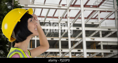 Composite image of female architect in hard hat looking away against white background Stock Photo