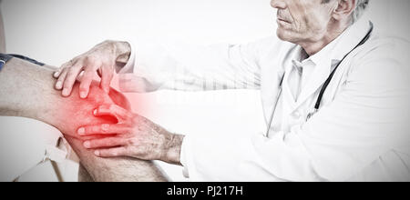 Composite image of side view of a mature doctor examining patients knee Stock Photo