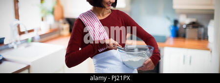 Composite image of female chef mixing flour in bowl with whisk Stock Photo