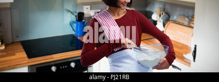 Composite image of female chef mixing flour in bowl with whisk Stock Photo