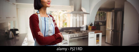 Composite image of waitress standing with arms crossed against white background Stock Photo