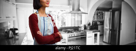 Composite image of waitress standing with arms crossed against white background Stock Photo