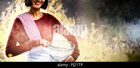 Composite image of smiling female chef mixing flour in bowl with whisk Stock Photo