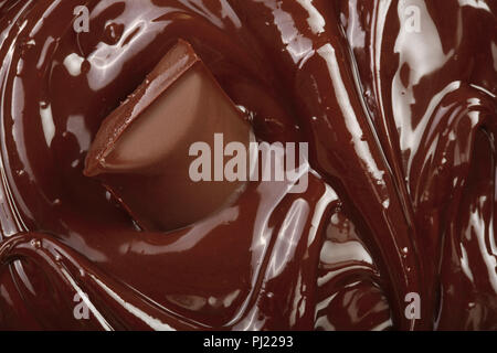 Melted chocolate and pieces of chocolate bar as a background closeup. Stock Photo