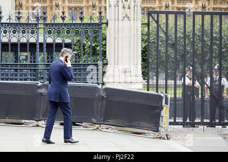 London, UK. 4th September 2018. British Conservative party politician and Member of Parliament Jacob Rees-Mogg on his phone passing the Houses of Parliament today. Credit: Kevin Frost/Alamy Live News Stock Photo