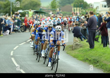 Timsbury, England. 4th sept 2018. Stage 3 of the 2018 OVO Energy Tour of Britain cycle race. The pelaton lead out by Team Quick-Step Floors chases down the leading four riders of the stage as the race passes through Timsbury. The large cheering crowd applauds their efforts. The race heads on towards the villages of High Littleton, Farmborough and Marksbury. Credit Simon Carder/Alamy Live News Stock Photo