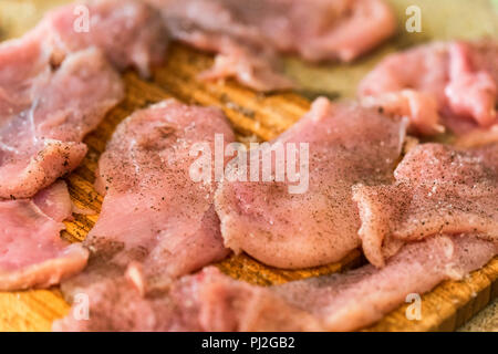 Pounded raw meat on wooden cutting board Stock Photo