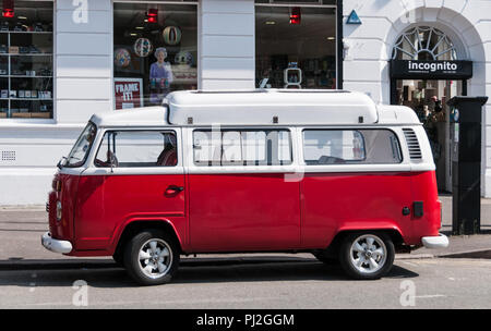 Red and white VW camper van parked outside Incognito in Manchester Stock Photo